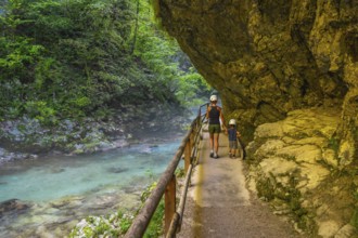 Tourists walking along the radovna river in vintgar gorge, near bled, slovenia, enjoying the
