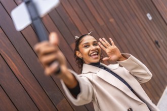 African american young female Content creator recording a new vlog using phone in the city