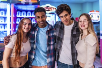 Four young multiethnic friends are smiling and having fun at an arcade, enjoying the weekend