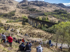 Tourists waiting for the jacobite steam train at the Glenfinnan viaduct, scottish highland,