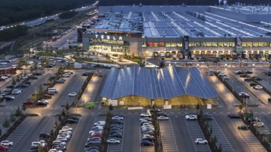 Tesla Giga Factory at the blue hour, centre, photovoltaic system above a charging station for