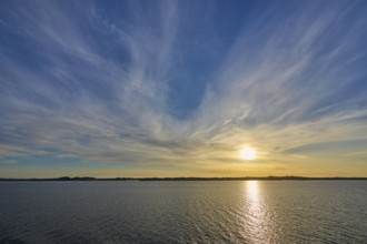 Sunrise over the calm sea, with wide sky and soft clouds in warm light, Bergen, Vestland, Norway,