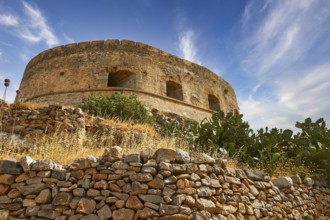 An old round tower on a hill with cacti and a clear blue sky, Venetian Sea Fortress, Leper Island,