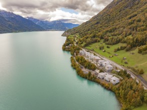 Lake with neighbouring buildings on the mountain slopes under a cloud cover, Lake Brienz.