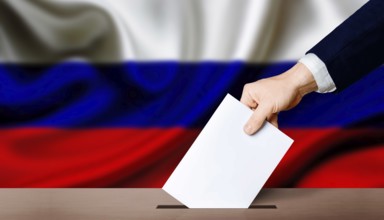Presidential elections of the Russian Federation. Hand holding ballot in the ballot box with Russia