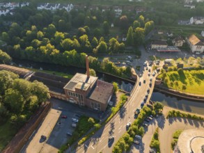 Aerial view of an industrial building cloth and ceiling factory with chimney next to a road with
