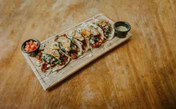 Traditional tacos al pastor with sauces served on a wooden board. Delicious Mexican chicken tacos