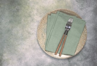 A plate with a kitchen towel and two forks, food wallpaper, food concept, top view, no people