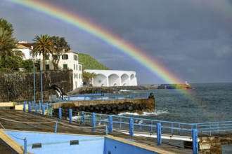 Promenade in rainy weather with rainbow on the beach of the Atlantic Ocean, municipality of Santa