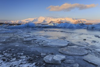 Ice floes in sea in front of glacier and mountains, morning light, Jökulsarlon, Vatnajökull,