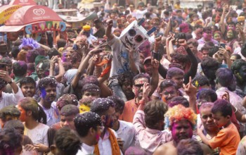 Revellers dancing in the beat of music as they celebrate Holi on a street, the Hindu spring