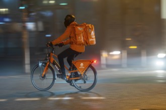 Lieferando courier, Lierferdienst cyclist, darkness, inner city traffic, fog, autumn, winter, North