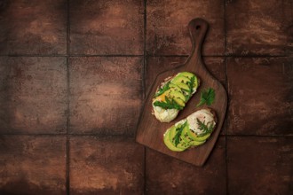 Sandwich with cream cheese, sliced avocado and boiled egg, arugula, on grainy bread, homemade,