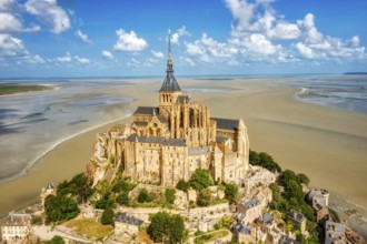 Majestic abbey on an island, surrounded by vast sand, under a clear sky, Le Mont-Saint-Michel