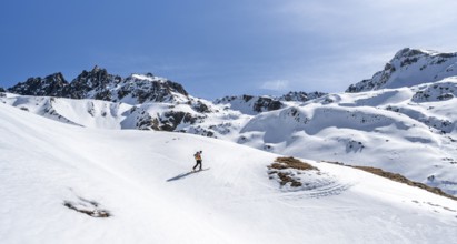 Ski tourer in mountain landscape with snow, ascent to Grialetsch Scharte, Bündner Haute Route,