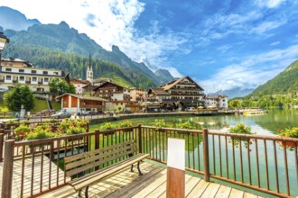 Tourists strolling along the picturesque shores of alleghe lake in the stunning dolomites on a