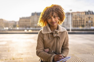 Beauty latin woman sketching on notebook sitting in the city