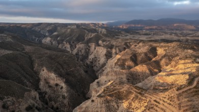 Sunrise, wide hilly desert landscape with dry vegetation, Gorafe desert, semi-desert, Granada,