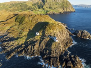 Aerial view of Krakenes Fyr lighthouse, lighthouse located on steep cliff, norwegian coast north of