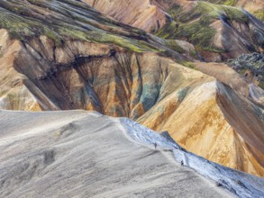 Hikers decending the slopes of Mt. Blahnukur, colorful rhyolite mountains, lava field,