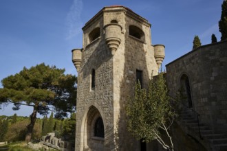 St John's Church, Historic stone tower with windows and stairs, surrounded by trees under a clear