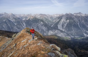 Mountaineer in front of a mountain panorama on a mountain ridge, view from the ridge of the Venet