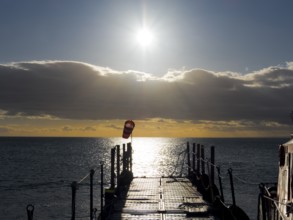 Jetty at sunrise over the sea on the Strait of Magellan, Punta Arenas, Chile, South America