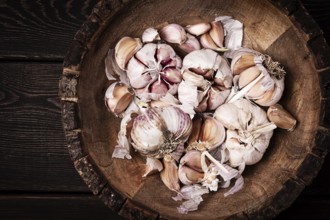 Fresh garlic, in a wooden plate, top view, close-up, no people