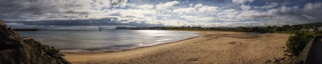 Extensive sandy beach overlooking the sea, cloudy skies and tranquil natural scenery, Ballycastle