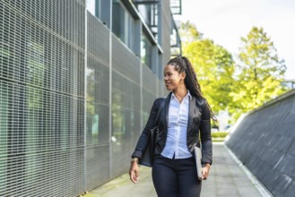 Horizontal photo with copy space of a modern latin businesswoman walking out the block office