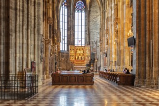 Bright Gothic church interior with impressive windows and decorated altar, Vienna