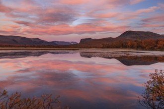 Mountains reflected in lake, autumn colours, cloudy mood, morning light, dawn, Nikkaluokta,