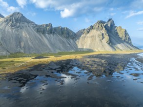 Aerial view of Mt. Vestrahorn, black lava beach, reflections on the water, Stokksnes, east of Höfn,