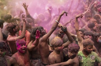 Revellers dancing in the beat of music as they celebrate Holi on a street, the Hindu spring