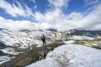 Mountaineer on hiking trail between snowfields, mountain landscape with summit Hoher Weißzint and