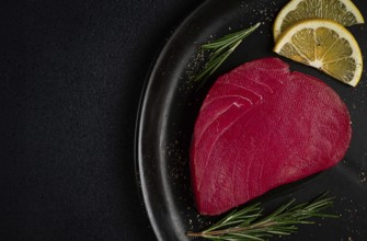 Fresh red tuna fillet, for steak, raw, top view, on a black plate, no people