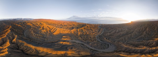 Panorama, riverbed runs through a landscape of eroded hills, badlands at sunrise, Issyk Kul Lake in