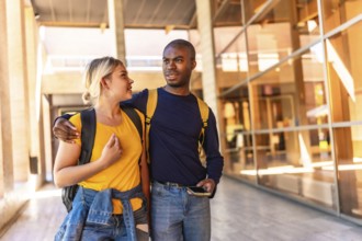 Multi-ethnic african and caucasian couple embracing walking along university