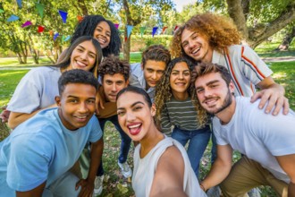 Frontal personal perspective view of a caucasian young woman taking selfie during party in a park