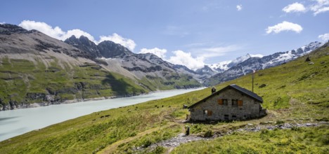 Alpine hut on a blue mountain lake, Lac des Dix reservoir, behind mountain peak Mont Blanc de