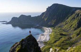 Climber on a rock, view of picturesque coastal landscape, steep coast with peak Måtind or Måtinden,