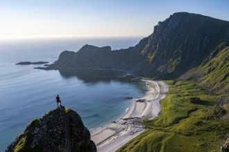 Climber on a rock, view of picturesque coastal landscape, steep coast with peak Måtind or Måtinden,