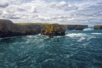Picturesque coastal scenery with deep blue sea, dramatic cliffs and cloudy skies, Kilkee