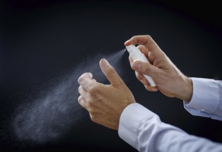 A man sprays wound disinfectant on his thumb in Berlin, 09/08/2024