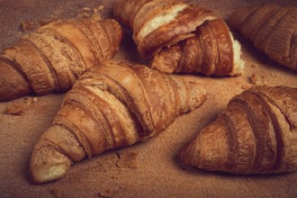 Fresh croissants, breakfast, top view, on the table, brown background, no people