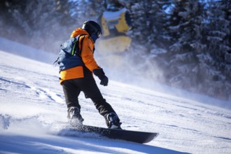 Oberjoch, Bavaria: Experienced snowboarder on a red piste