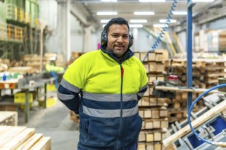 Portrait of a manual worker in a recycling plant next to pallets to arrange and reuse