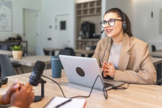 Two podcasters are recording a new episode in a modern studio, using professional equipment like