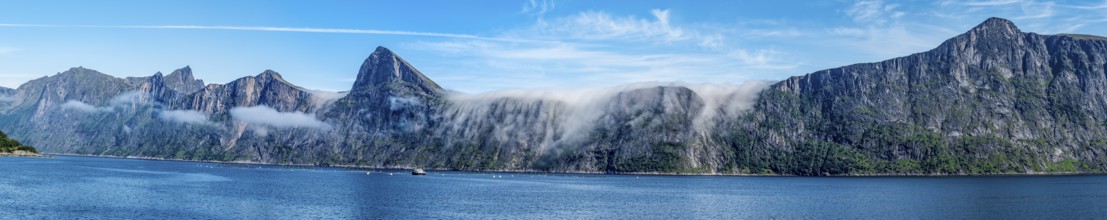 Panorama of fjord Mefjord with famous peaks Hesten, Segla and Grytetippen, salmon farm, Senja