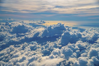 Golden hour sunlight illuminates a vast expanse of fluffy white clouds over coron island,